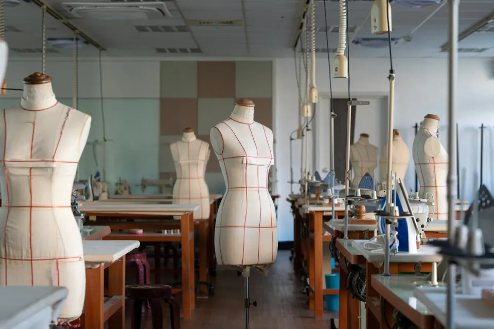 Empty modern sewing workshop with dress forms and industrial sewing machines